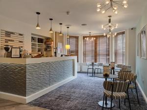 a restaurant with a bar with chairs and tables at Linton Lodge a BW Signature Collection Hotel in Oxford