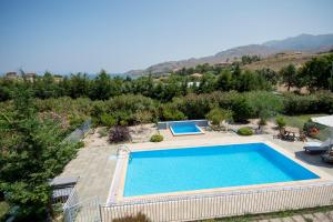 a swimming pool in a yard with trees and mountains at Anasa Villas in Mithymna