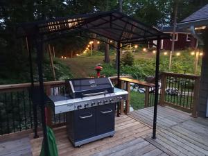 einen Grill unter einer hölzernen Pergola auf einer Terrasse in der Unterkunft Fireside - Waterfront Resort Style Executive Cottage in Kawartha Lakes