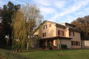 uma casa grande com uma árvore no quintal em Poggio Guicciardino em Venturina Terme