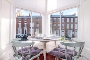 a table and two chairs in a room with a window at Bramblewick in Whitby