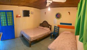 een slaapkamer met 2 bedden en een blauwe deur bij Hostal Paraíso Teenek Tambaque 