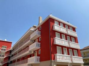 a red building with white balconies on it at Marebello in Rosolina