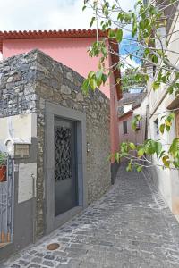 ein Steingebäude mit einer Tür auf einer Straße in der Unterkunft Alojamento Príncipe D.Luís in Ponta do Sol
