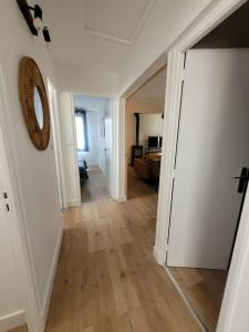 a hallway leading to a living room with a clock on the wall at Le Cocon - Barneville plage in Barneville-Carteret