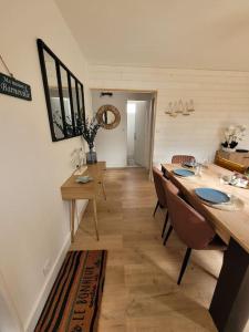 a dining room with a long table and chairs at Le Cocon - Barneville plage in Barneville-Carteret