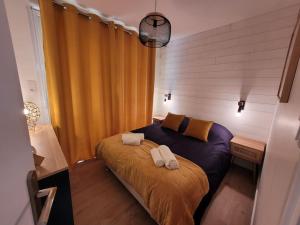1 dormitorio con 1 cama con 2 toallas en Le Cocon - Barneville plage, en Barneville-Carteret