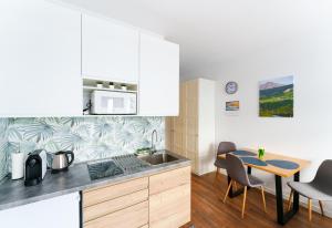 a kitchen with a sink and a table with chairs at Aparta Lotnisko in Wrocław