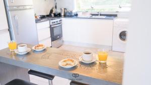 cocina con mesa y 2 tazas de zumo de naranja en Departamento con Vista Panorámica al Lago en San Carlos de Bariloche