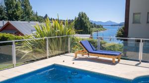 una silla azul sentada en un patio junto a una piscina en Departamento con Vista Panorámica al Lago en San Carlos de Bariloche