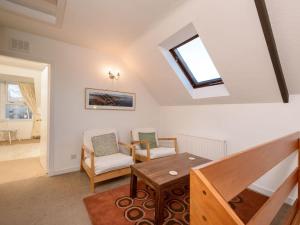 uma sala de estar com uma clarabóia, uma mesa e cadeiras em Printer`s Place em North Berwick