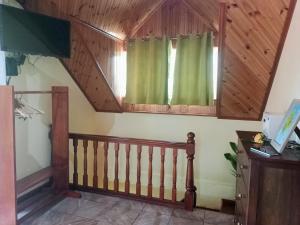 Habitación con escalera y ventana verde. en Badamier Self-Catering en La Digue