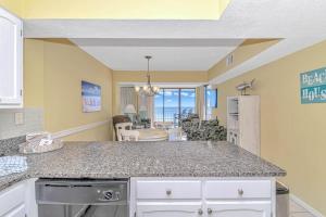 a kitchen with a counter top and a living room at Serenity By The Sea I Crescent Sands I Windy Hill I North Myrtle Beach in Myrtle Beach