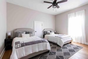 a bedroom with two beds and a ceiling fan at Newly Renovated 3 Bedroom Shelby Park Home **FREE PARKING** in Louisville
