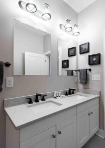 a bathroom with a sink and a large mirror at Newly Renovated 3 Bedroom Shelby Park Home **FREE PARKING** in Louisville