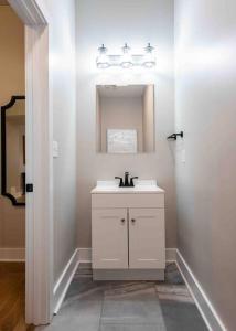 a white bathroom with a sink and a mirror at Newly Renovated 3 Bedroom Shelby Park Home **FREE PARKING** in Louisville