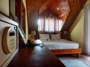 um quarto com uma cama grande num sótão em Badamier Self-Catering em La Digue