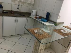 cocina con 2 mesas de cristal y encimera en Apartamento aconchegante próx ao Centro - 1 quarto, en Vitória da Conquista
