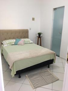 a bedroom with a bed with a green comforter at Apartamento aconchegante próx ao Centro - 1 quarto in Vitória da Conquista