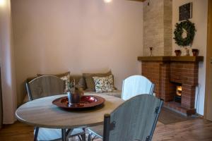 a table and chairs in a living room with a fireplace at Rubeņi Jūrmala in Jūrmala