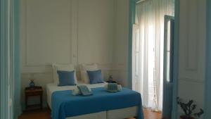 a bedroom with a bed with a blue blanket at OlhãOmirante Guesthouse in Olhão