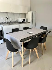 a kitchen with a table and chairs in a kitchen at COMPLEJO PALERMO SUITES in San Juan