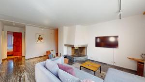 a living room with a couch and a fireplace at Abitaziun Curtins 1 6 - La Punt Chamues-ch in La Punt-Chamues-ch