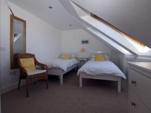 Cette chambre mansardée comprend 2 lits et un miroir. dans l'établissement Quayside Cottage, à North Berwick