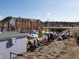 a group of people sitting on a dock near a marina at Quayside Cottage in North Berwick