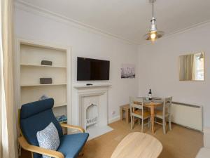 ein Wohnzimmer mit einem TV und einem Esstisch in der Unterkunft Pebbles Apartment in North Berwick