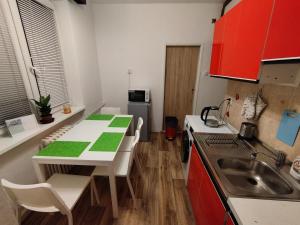 a small kitchen with a table and a sink at apartmán Mirabella in Královo Pole