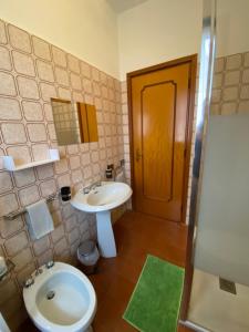 La salle de bains est pourvue d'un lavabo, de toilettes et d'un miroir. dans l'établissement B&B Segrino, à Longone al Segrino