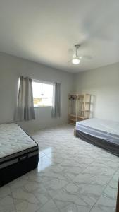 Un dormitorio grande con una cama y una ventana. en Duplex Praia do Bosque, en Guriri