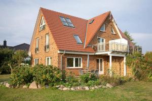 uma casa de tijolos com um telhado laranja em Ferienhaus Hideaway Haus - Terrasse, Garten, strandnah em Neuendorf