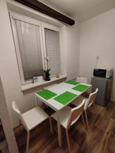 a dining room with a white table and chairs at apartmán Mirabella in Královo Pole