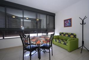 a dining room with a table and chairs and a couch at Gemelos 26 - Fincas Arena in Benidorm