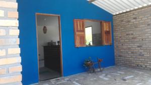 een blauwe kamer met een spiegel en een bakstenen muur bij Chalet Vida de Roça in Ibicoara
