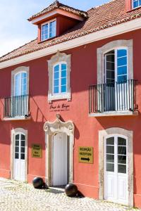 uma casa vermelha com portas e janelas brancas em Paço do Bispo Boutique House em Sintra