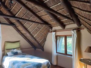 a bedroom with a bed and a window at Fijnbosch Self Catering Chalet in Jeffreys Bay