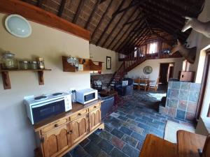 a living room with a microwave on a wooden counter at Fijnbosch Self Catering Chalet in Jeffreys Bay