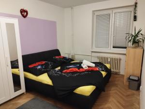 a bedroom with a bed with black and yellow sheets at apartmán Mirabella in Královo Pole