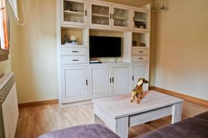 a living room with a table and a tv at Urbión Etxea in Viana