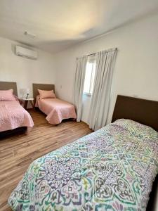 een slaapkamer met 2 bedden en een raam bij COMPLEJO PALERMO SUITES in San Juan