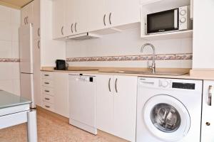 a kitchen with a washing machine and a microwave at Urbión Etxea. in Viana