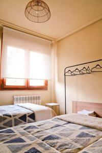a bedroom with two beds and a window at Urbión Etxea. in Viana