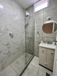 y baño con ducha y lavamanos. en COMPLEJO PALERMO SUITES en San Juan