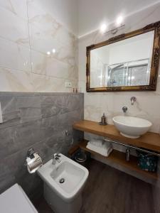 a bathroom with a sink and a toilet and a mirror at Affittacamere Perla del Prione in La Spezia