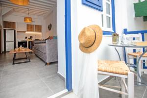 a living room and kitchen with a hat on the door at Aelia Suite I / Mykonos Town in Mikonos
