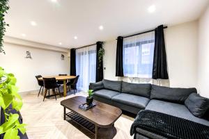 a living room with a couch and a table at Lovely 1-bed flat with a balcony & garden access in London