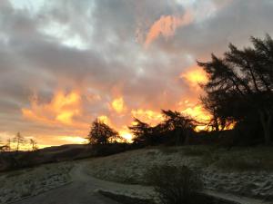 a dirt road with a sunset in the background at Silver Well Cottage in Ilkley